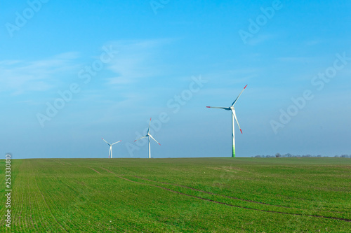 wind generators in a field on a clear sunny day
