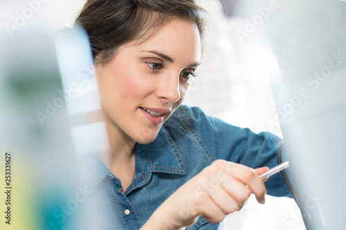 close-up of smiling woman concentrating and holding a pen