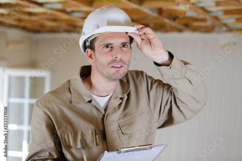 building inspector holding clipboard in property under renovation