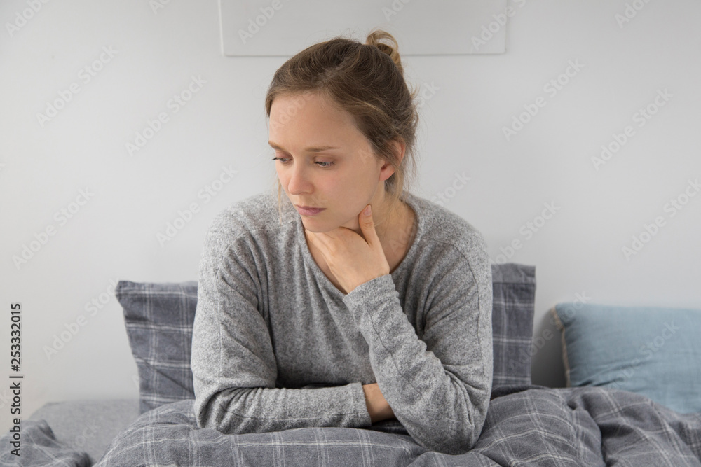 Sick woman taking napkin at face, holding laptop on knees Sick woman taking napkin at face, holding laptop on knees