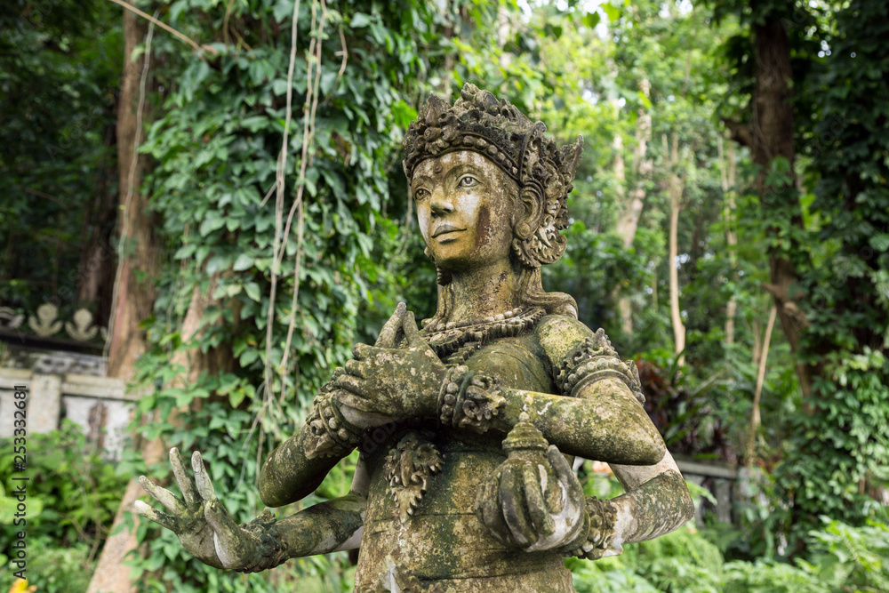 Stone idol of multiarm god in Bali, Indonesia.