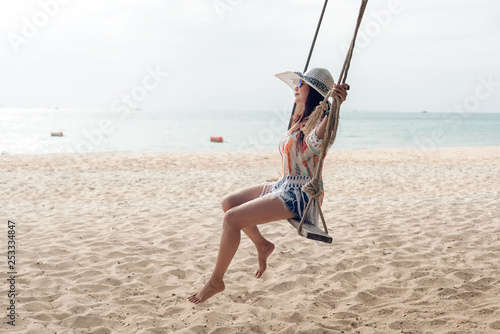 Summer Vacations. Lifestyle women relaxing and enjoying swing on the sand beach, fashion stunning women with white dress on the tropical island so happy and luxury in holiday summer. Travel and Summer