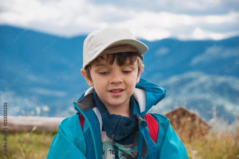 Little boy with a backpack hiking mountains. Best summer hikes.