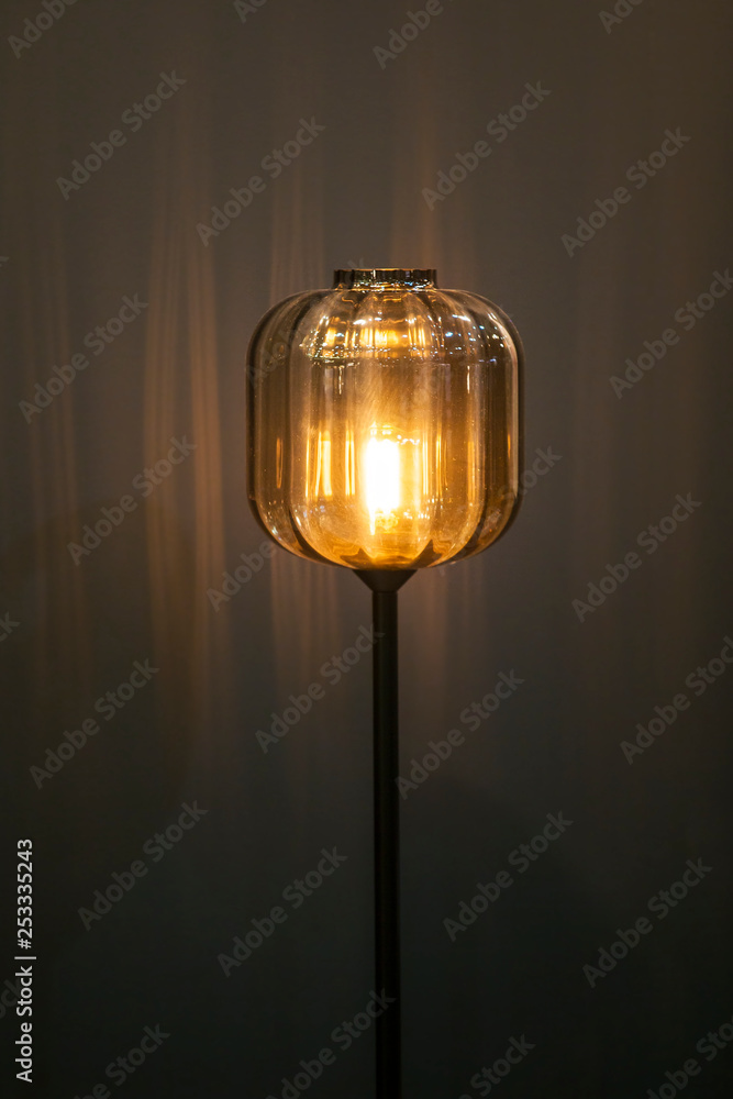 Floor glass lamp. Lantern, floor lamp in loft style, minimalistic glass lamp with yellow light