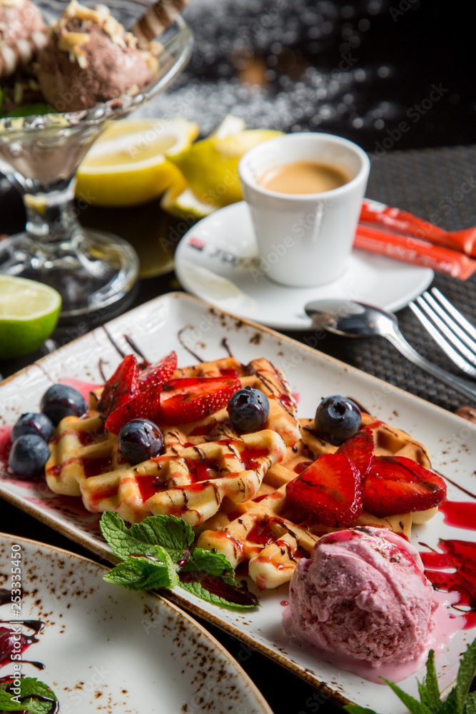 sweet Viennese waffles with syrup and sauce. Fresh fruit and berries in dessert. sweet dessert. sweet Viennese waffles with syrup and sauce. Fresh fruit and berries in dessert. sweet dessert.
