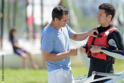 instructor checking life jacket is secure on young man