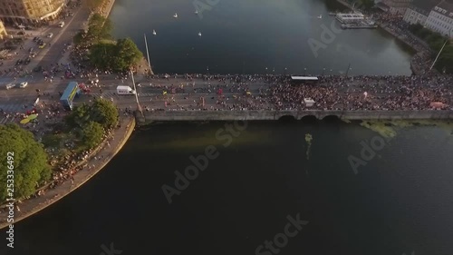 Aerial shot looking down over partying crowd on bridge Dronning Louises Bro flying away revealing the city view and lake during sunset at Distortion Music Festival photo
