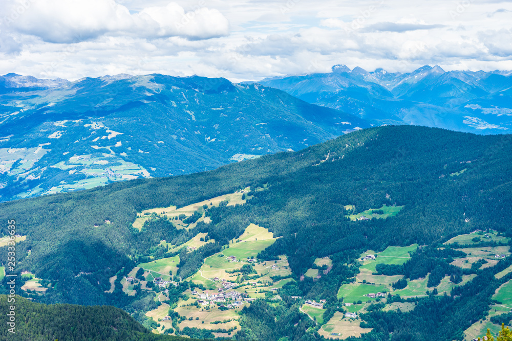 Fototapeta premium Alpe di Siusi, Seiser Alm with Sassolungo Langkofel Dolomite, a view of a large mountain in the background