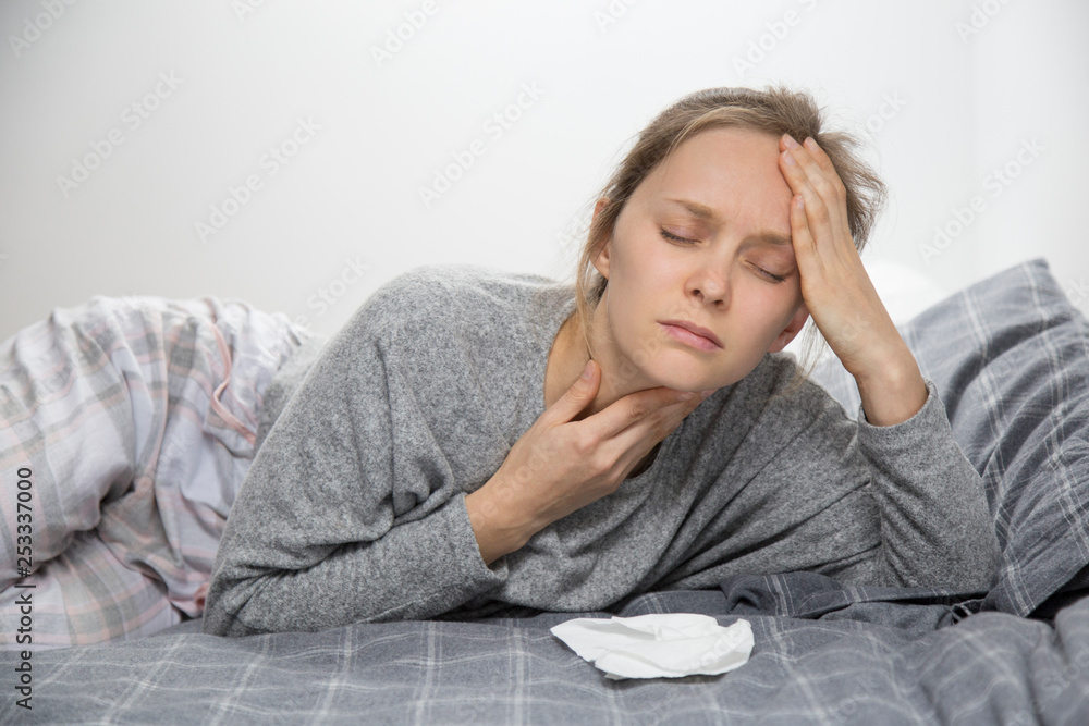 Tired sick woman in bed with closed eyes having sore throat Tired sick woman in bed with closed eyes having sore throat