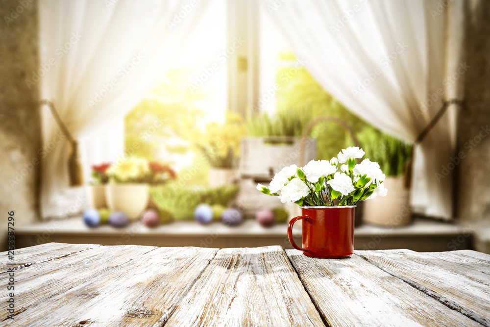 Fototapeta premium Wooden table of free space for your decoration. Spring window background. Easter eggs and flowers on window sill. 