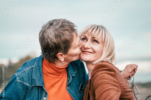 Elderly mother tenderly kissing his daughter. Concept - Maternal love and family
