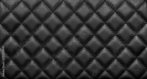Close-up texture of genuine leather with black rhombic stitching photo
