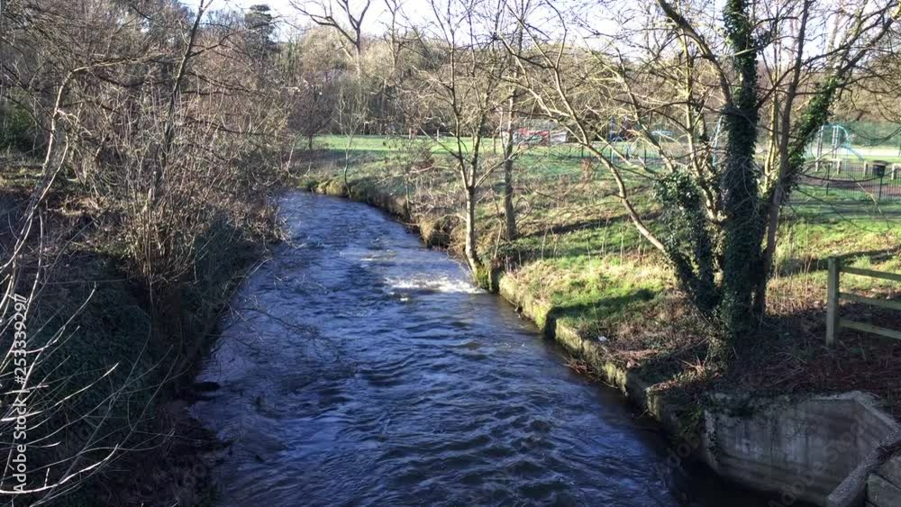 View of The River Bollin from the road bridge by St Bartholomew’s churchyard in Wilmslow, Cheshire, England, on a sunny winter’s day. View of The River Bollin from the road bridge by St Bartholomew’s churchyard in Wilmslow, Cheshire, England, on a sunny winter’s day.
