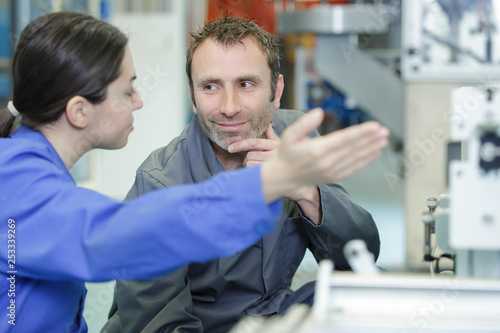 woman industrial engineer pointing at male woker at work