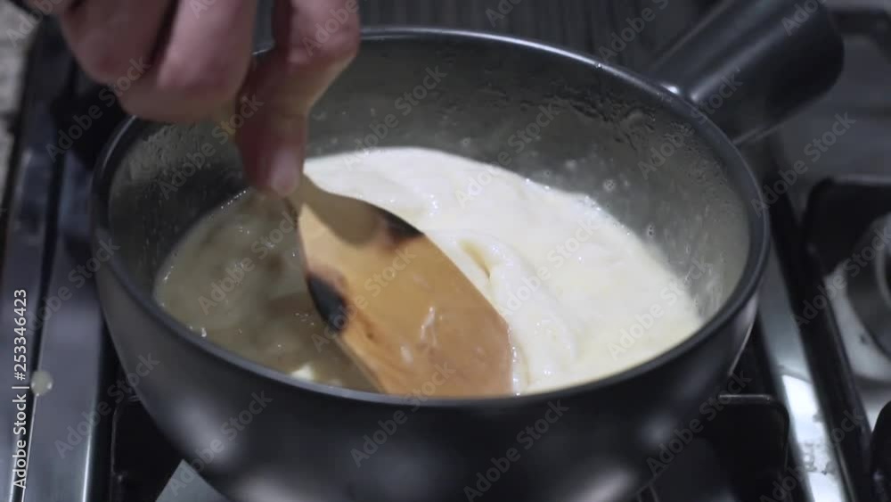 Slow Motion: Melting Cheese in a pot for fondue Slow Motion: Melting Cheese in a pot for fondue