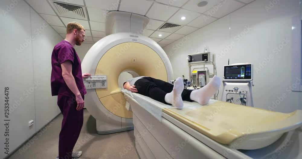 Picture of young doctor controlling moving bed Picture of young doctor controlling moving bed