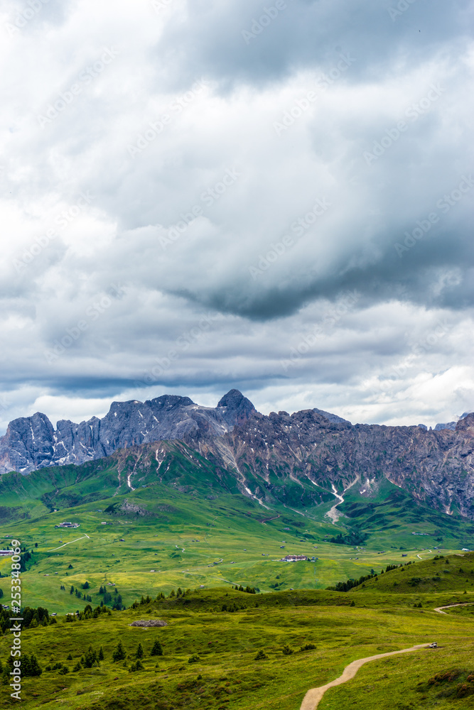 Alpe di Siusi, Seiser Alm with Sassolungo Langkofel Dolomite, a field with a mountain in the background Alpe di Siusi, Seiser Alm with Sassolungo Langkofel Dolomite, a field with a mountain in the background