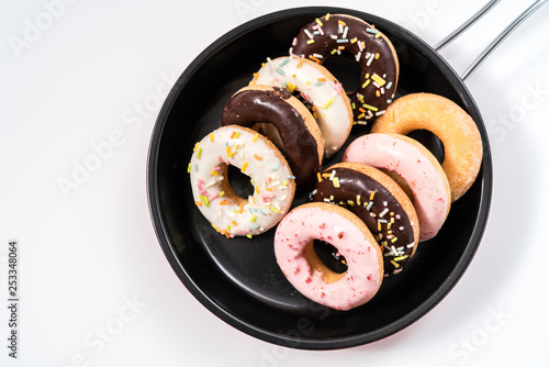 Donuts and drink and iron frying panon white background top view copy space pattern photo