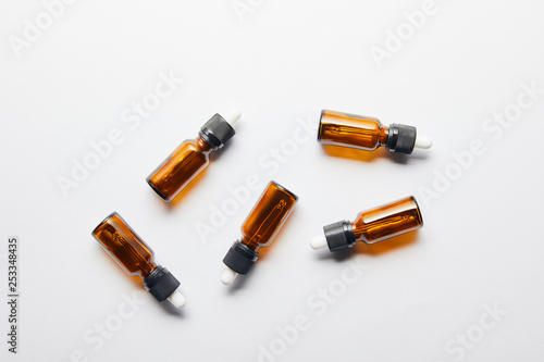 Top view of brown bottles with essential oil lying on grey surface