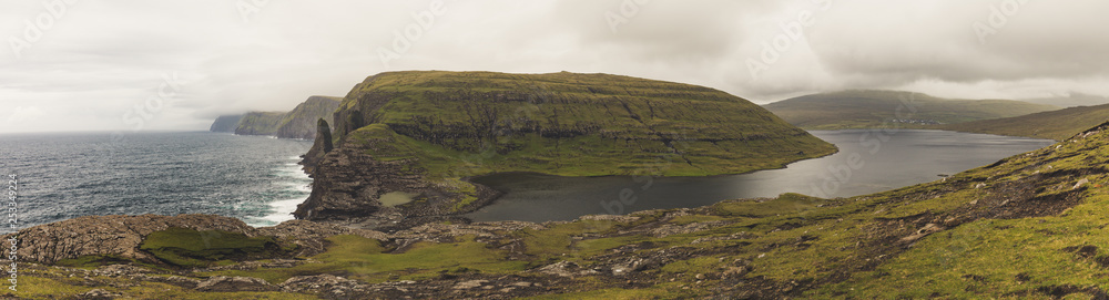 panorama of the Bosdalafossur waterfall hike around the Sorvagsvatn lake at the Vagar Island of the Faroe islands archipelago in the summer 