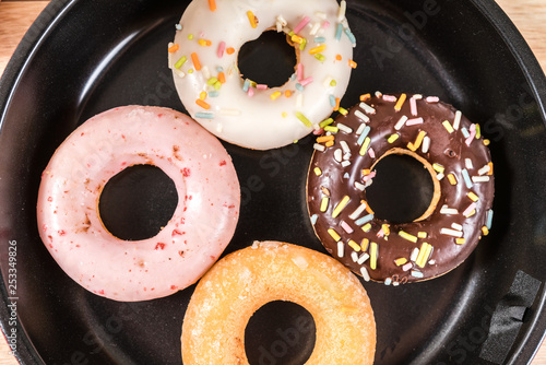 Donuts and drink and iron frying panon wood table background top view copy space pattern photo