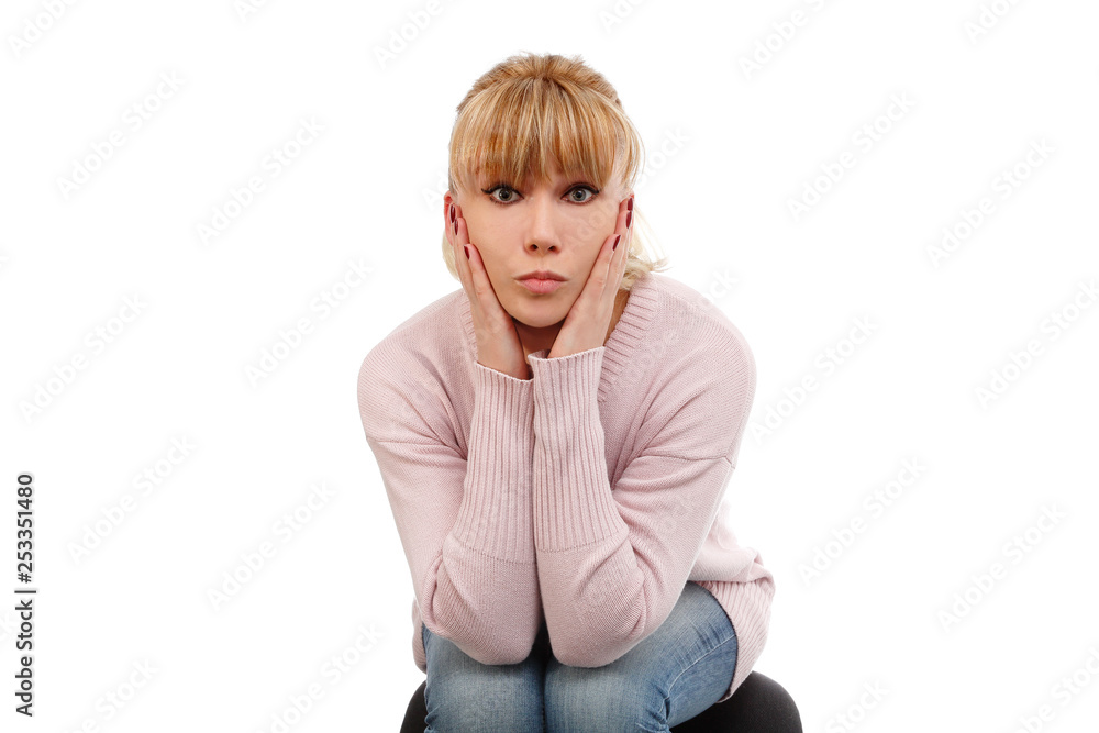 Sad beautiful blonde thinks. Model blonde sad on white background. The girl thinks about the problems. A sad woman is sitting on a chair. Banner with a thinking girl Sad beautiful blonde thinks. Model blonde sad on white background. The girl thinks about the problems. A sad woman is sitting on a chair. Banner with a thinking girl