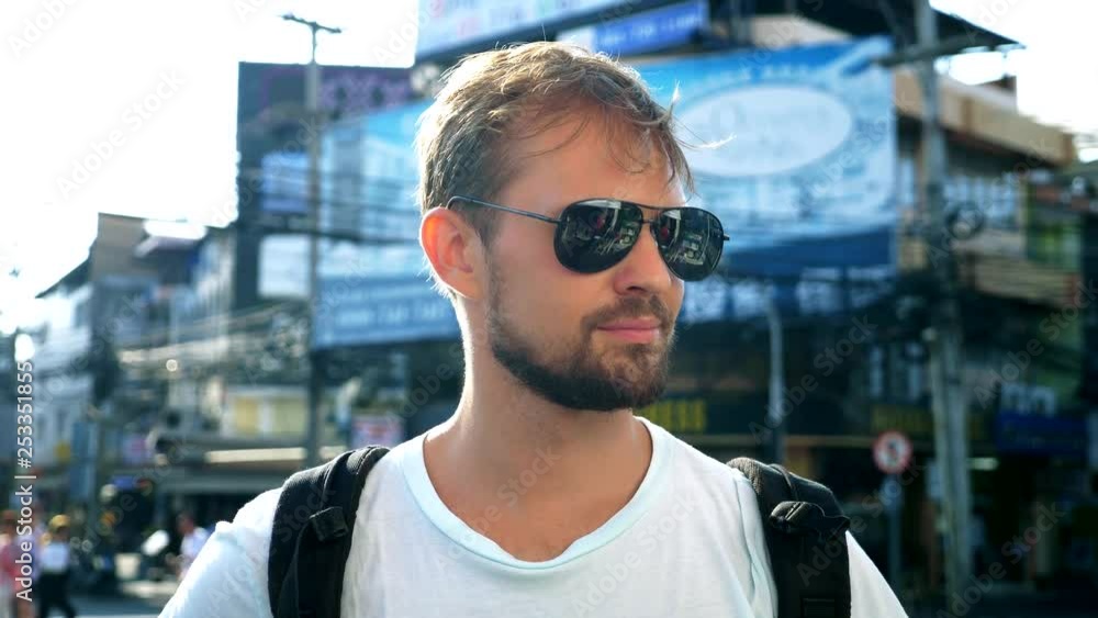 Bearded young man in sunglasses standing on the road. Taxi concept Bearded young man in sunglasses standing on the road. Taxi concept