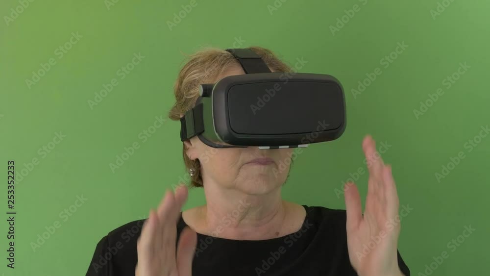 Close up of a senior Woman putting her VR googles and looking fast with wonder in green screen Close up of a senior Woman putting her VR googles and looking fast with wonder in green screen