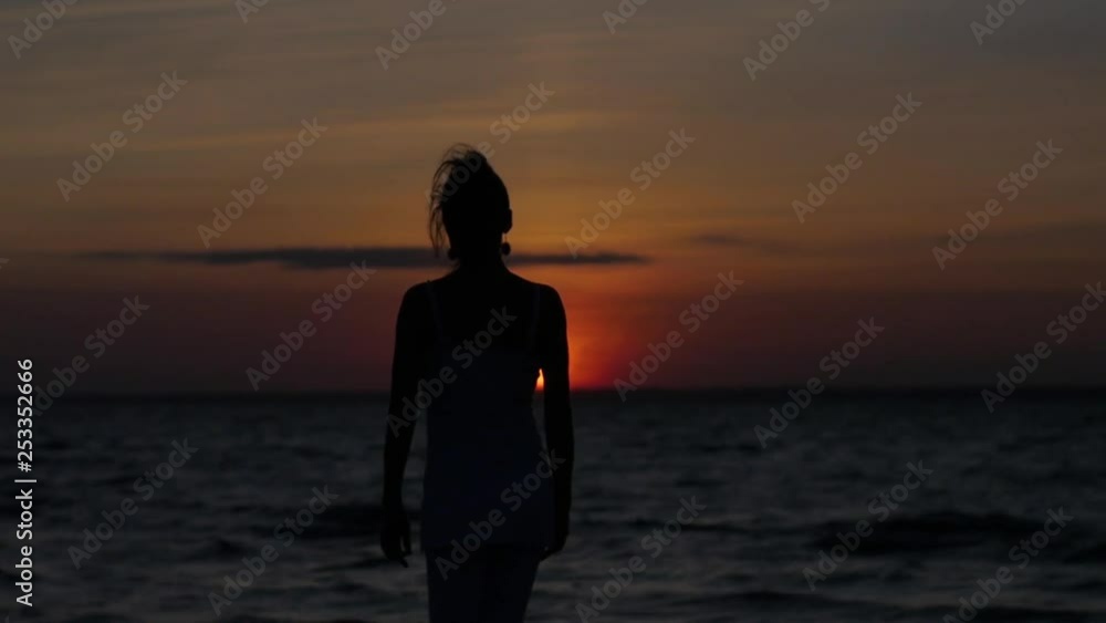 silhouette of a woman who dances against the backdrop of the sunset and the sea silhouette of a woman who dances against the backdrop of the sunset and the sea