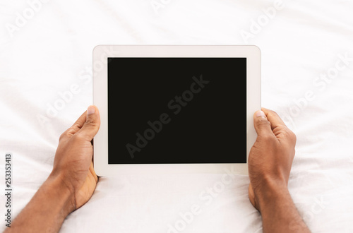 Modern big digital tablet with blank screen in bed