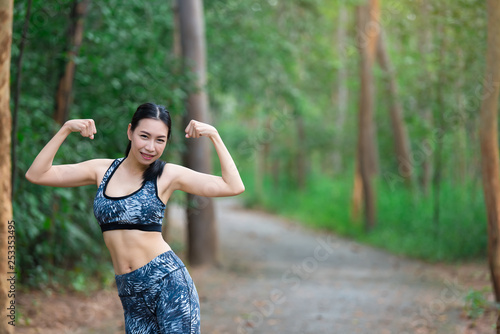 Asian sporty woman stretching body breathing fresh air in the park,Thailand people,Fitness and exercise concept,Jogging in the park,Warm up body