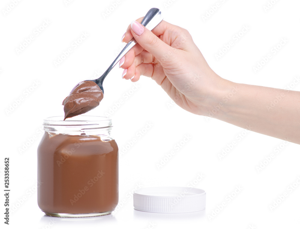 A jar of chocolate spread, spoon in hand on white background isolation A jar of chocolate spread, spoon in hand on white background isolation