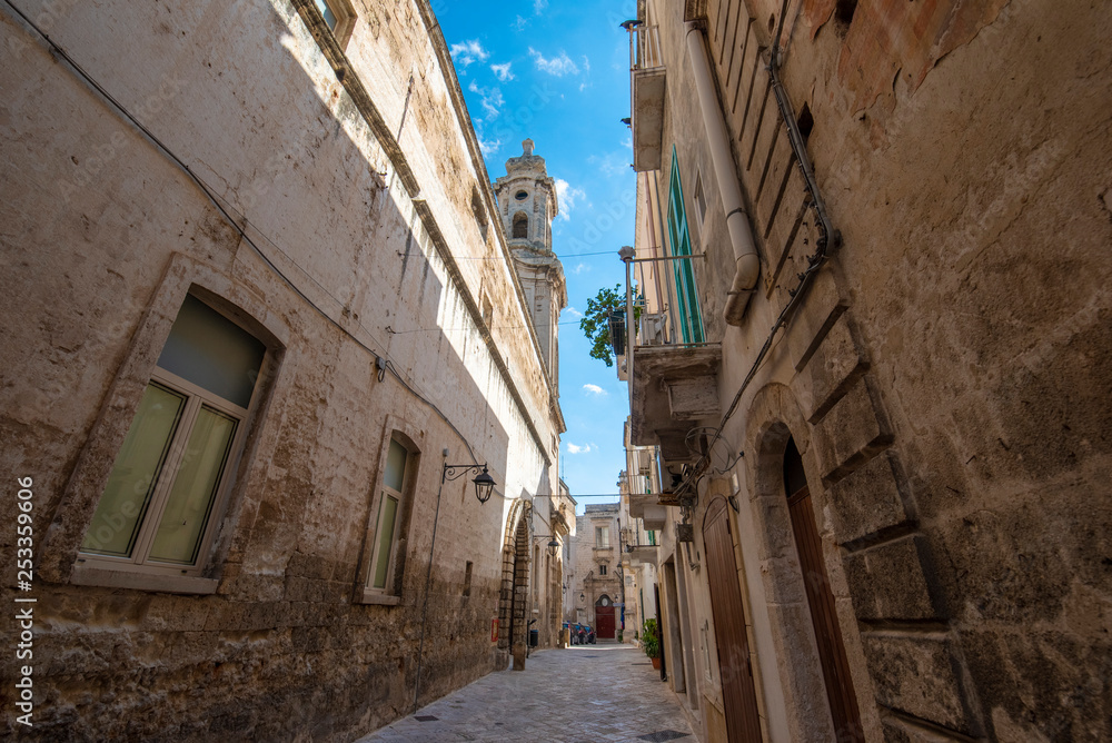 Street and alley with a view to the bell tower of Church of Saint Joseph and Anna  (Chiesa dei Santi Giuseppe e Anna) in the old town of Monopoli, Puglia, Italy. A region of Apulia
