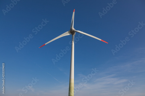 wind turbine with sun flare blue sky background view from below © Dmitriy Popov