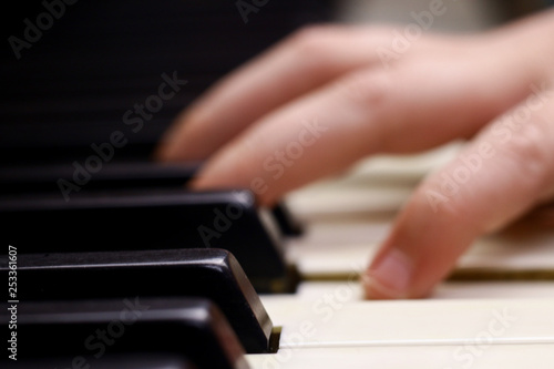 Antique piano keys and blurred fingers in background.