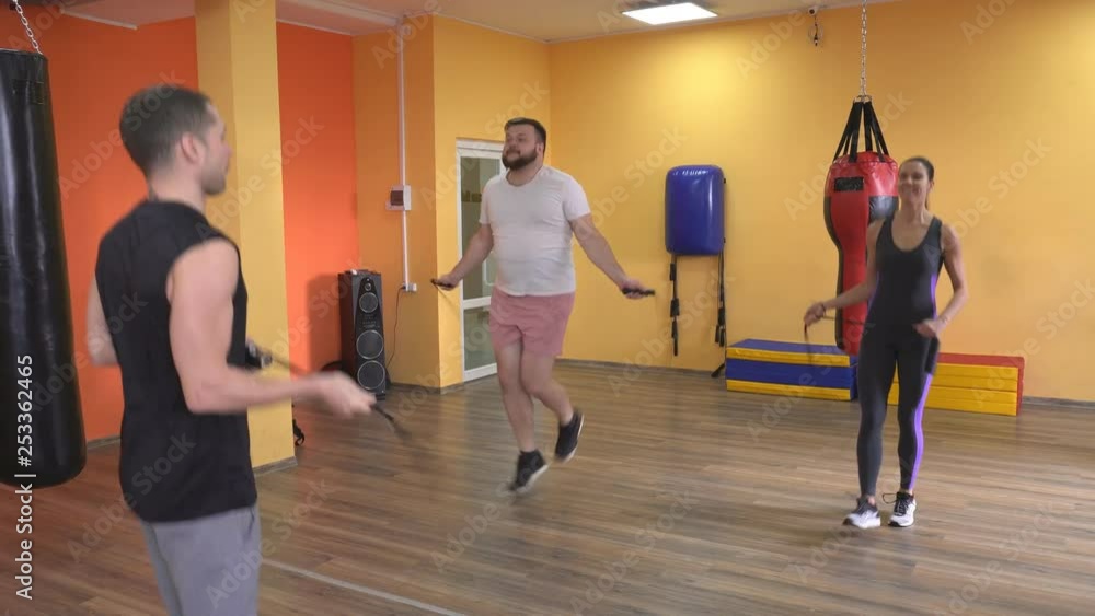 Bearded man and girl jump on a rope in the gym under the supervision of a trainer, warm up before training boxing, jumping-rope Bearded man and girl jump on a rope in the gym under the supervision of a trainer, warm up before training boxing, jumping-rope