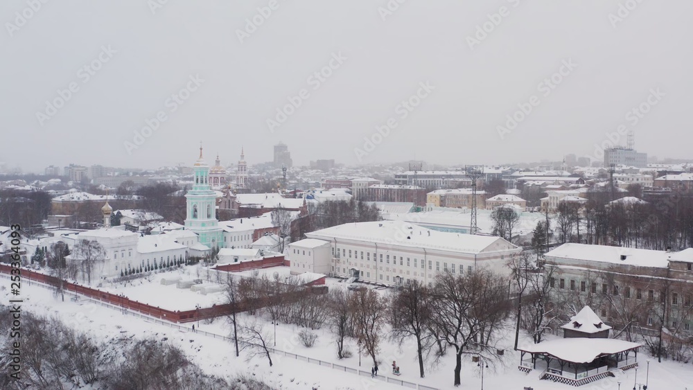 the city of Kirov and the high bank of the river Vyatka and the Alexander Grin Embankment and the rotunda on a cloudy winter day.