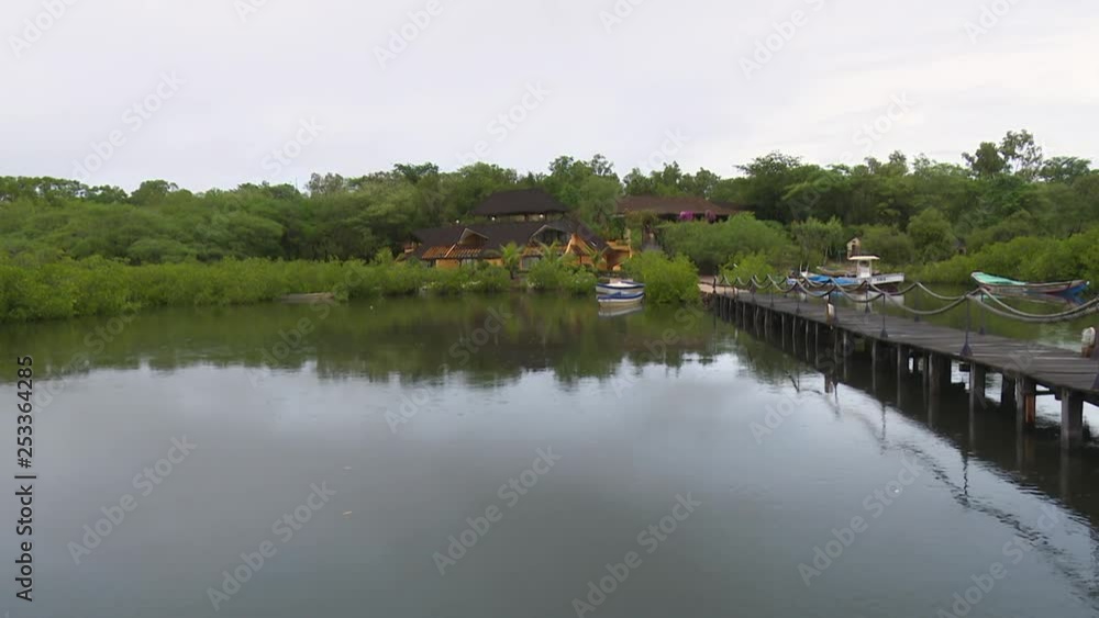 View of tourist accommodation in Senegal from a pier on a tropical river View of tourist accommodation in Senegal from a pier on a tropical river