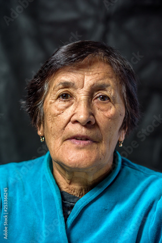 portrait of an elderly thoughtful woman on a dark background