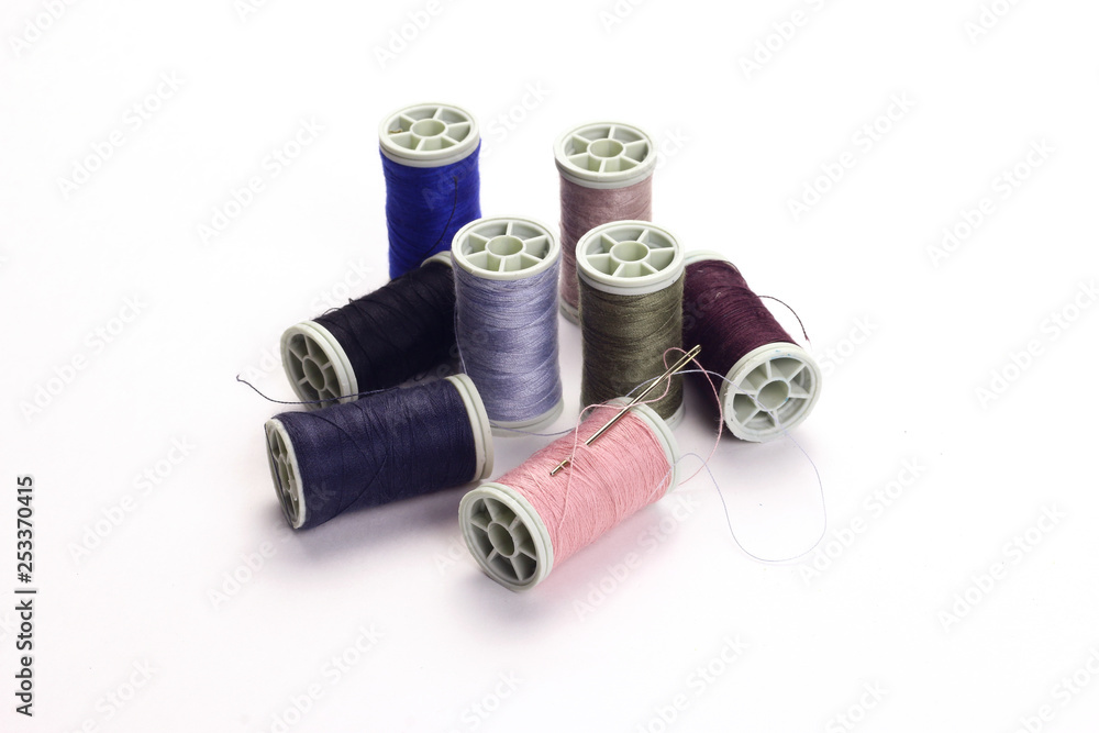 Different color spools of thread with needle. Different color spools of thread with needle.