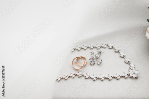 Beautiful toned picture with wedding rings against the background of a bouquet of flowers