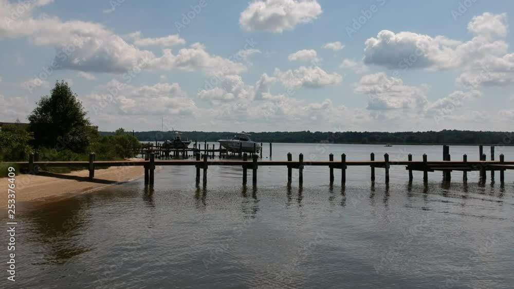 Blue skies above water as we pass by a dock Blue skies above water as we pass by a dock