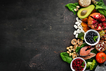Healthy food: Fish, blueberries, nuts, pomegranate, avocados, tomatoes, spinach, flax. Concept of Dietary Nutrition. Top view.