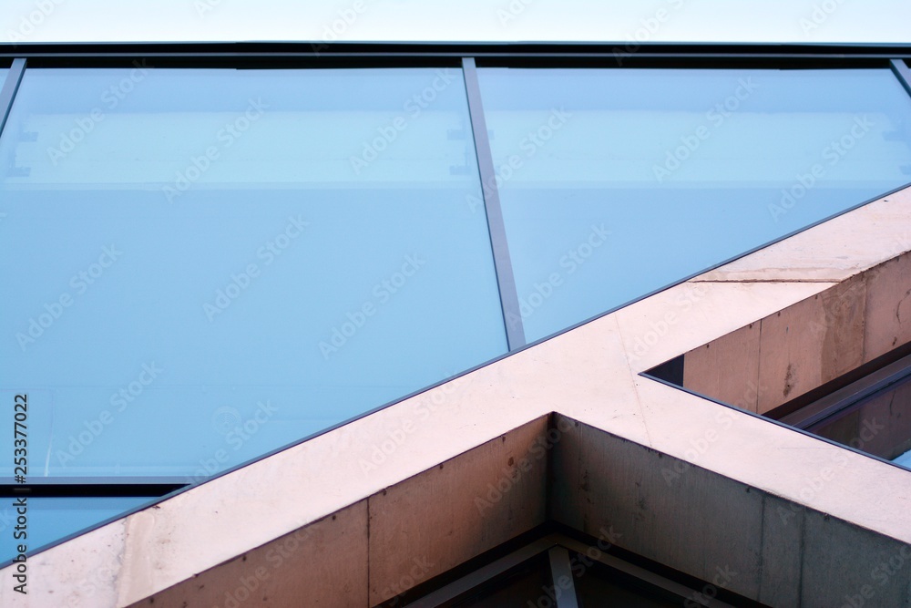 Fototapeta premium Abstract image of looking up at modern glass and concrete building. Architectural exterior detail of office building. 