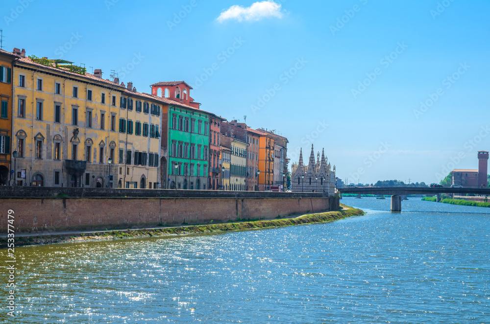 Obraz premium Row of old colorful buildings houses on embankment promenade of Arno river, Chiesa di Santa Maria della Spina church, Ponte Solferino bridge in historical centre of Pisa town, Tuscany, Italy