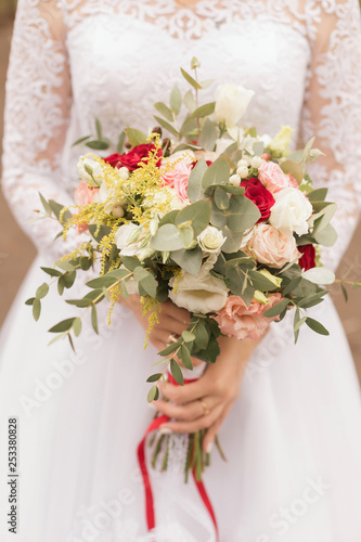 White wedding bouquet in the hands of the bride