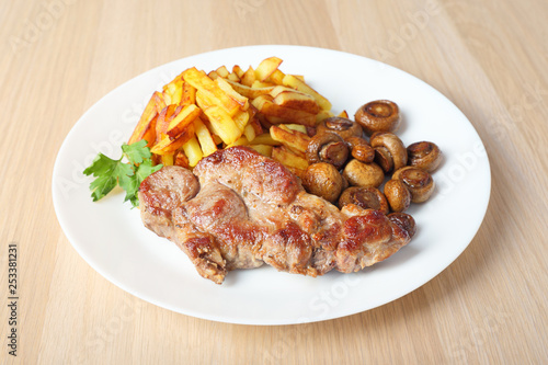 steak with fried potatoes and mushrooms side view