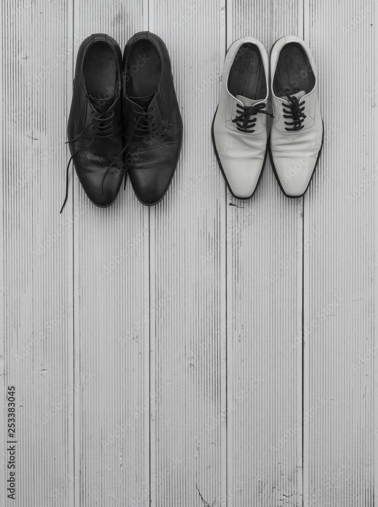 men's white and black shoes on a white wooden floor