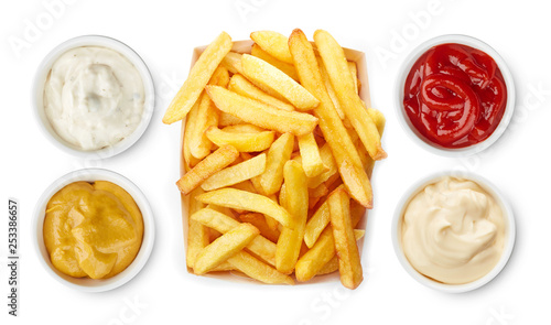 French fries with ketchup, mayonnaise, mustard, garlic sauce top view isolated on white background photo