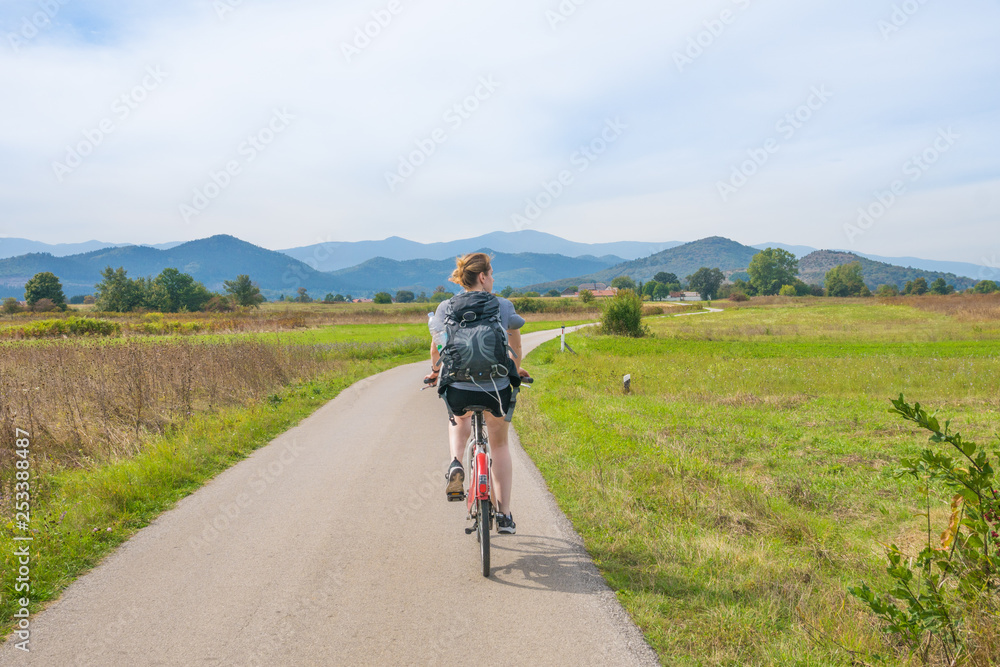 woman biking through the fields in central croatia woman biking through the fields in central croatia